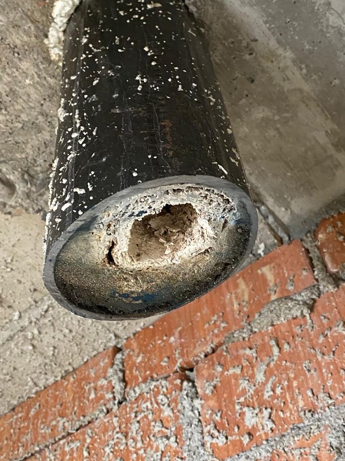 Aufgeschnittene alte Abwasserleitung, innen fast zugewachsen