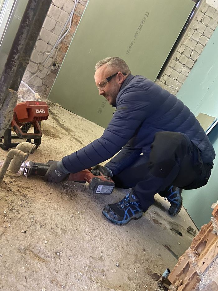 Monteur bei der Rohinstallation im entkernten Bad
